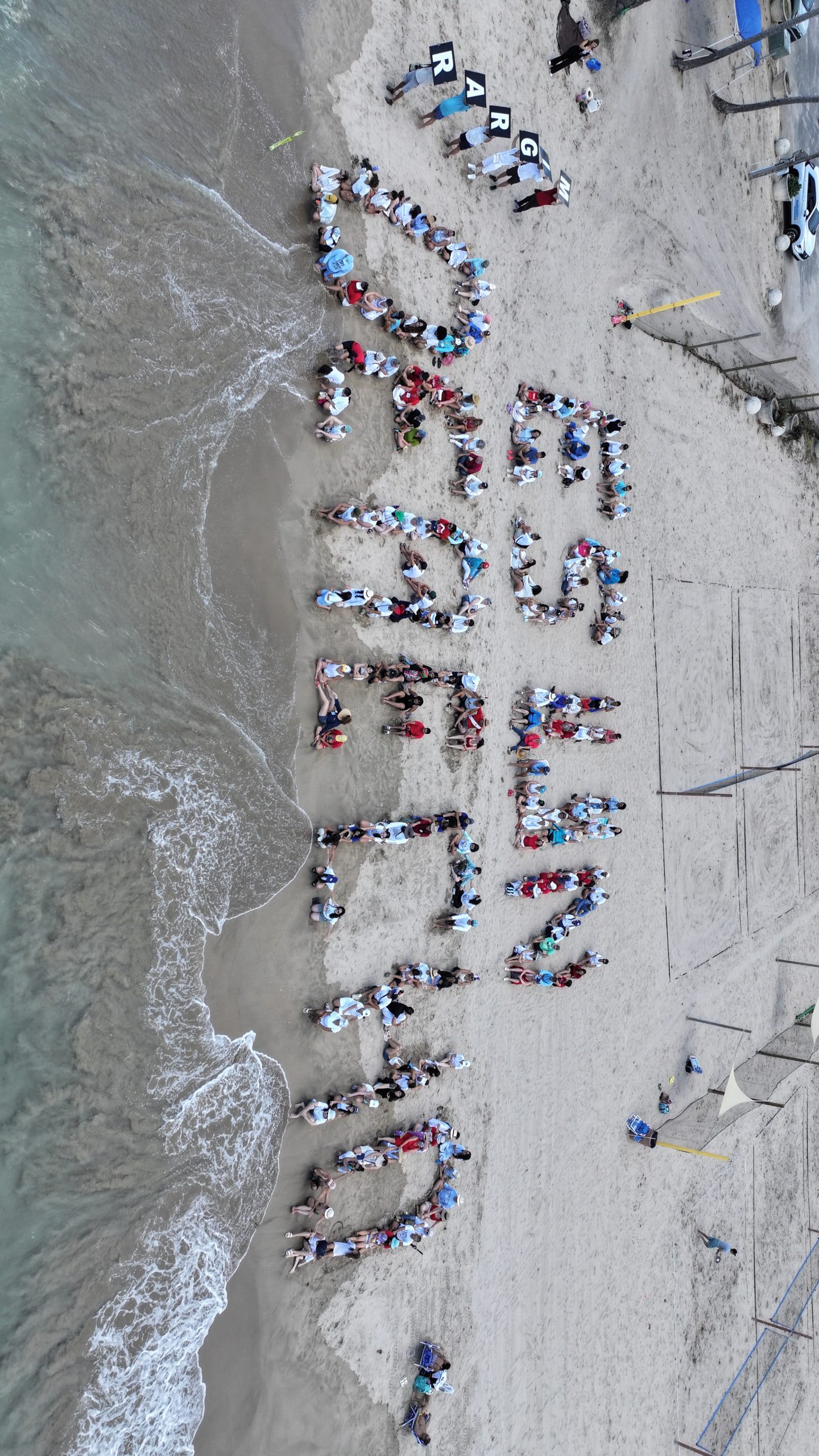 Más de 200 personas formaron la frase "Migrar es un derecho" en el Balneario de Carolina, Puerto Rico, en defensa de las personas inmigrantes que viven en el archipiélago.